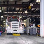 Classic big rig semi truck is being serviced in a specialized workshop equipped for semi truck repairs and maintenance