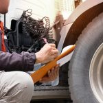 Inspection safety a trucks, truck driver holding clipboard with checking a truck tire.